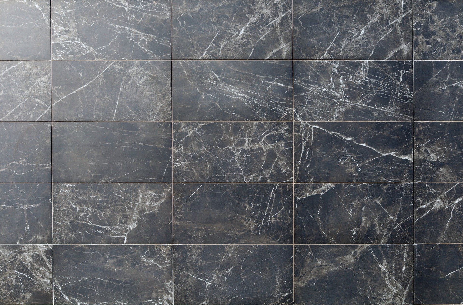 Elegant tiled wall with brownish  black marble with white streaks.